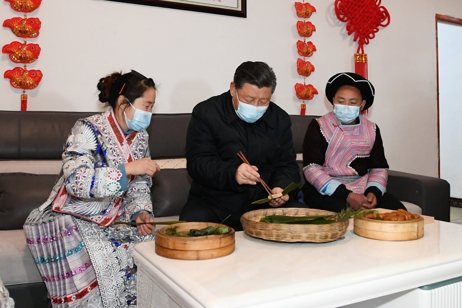 2021年2月3日下午，習近平在貴州畢節(jié)市黔西縣新仁苗族鄉(xiāng)化屋村苗族村民趙玉學家，同一家人邊聊家常邊制作當?shù)貍鹘y(tǒng)節(jié)日食品黃粑。新華社記者 李學仁 攝