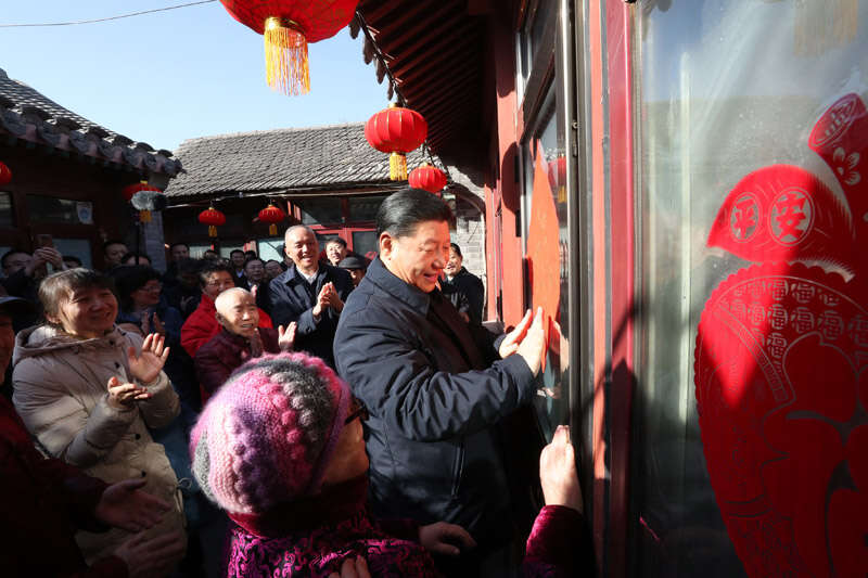2019年2月1日上午，習近平在北京前門東區(qū)草廠四條胡同32號院，高興地拿起一幅“福”字，親自貼到門上，給這里的老街坊們拜年。新華社記者 鞠鵬 攝