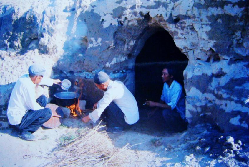 1983年，“六老漢”一代治沙人在“地窩子”生活做飯。新華社發(fā)（八步沙林場(chǎng)供圖）